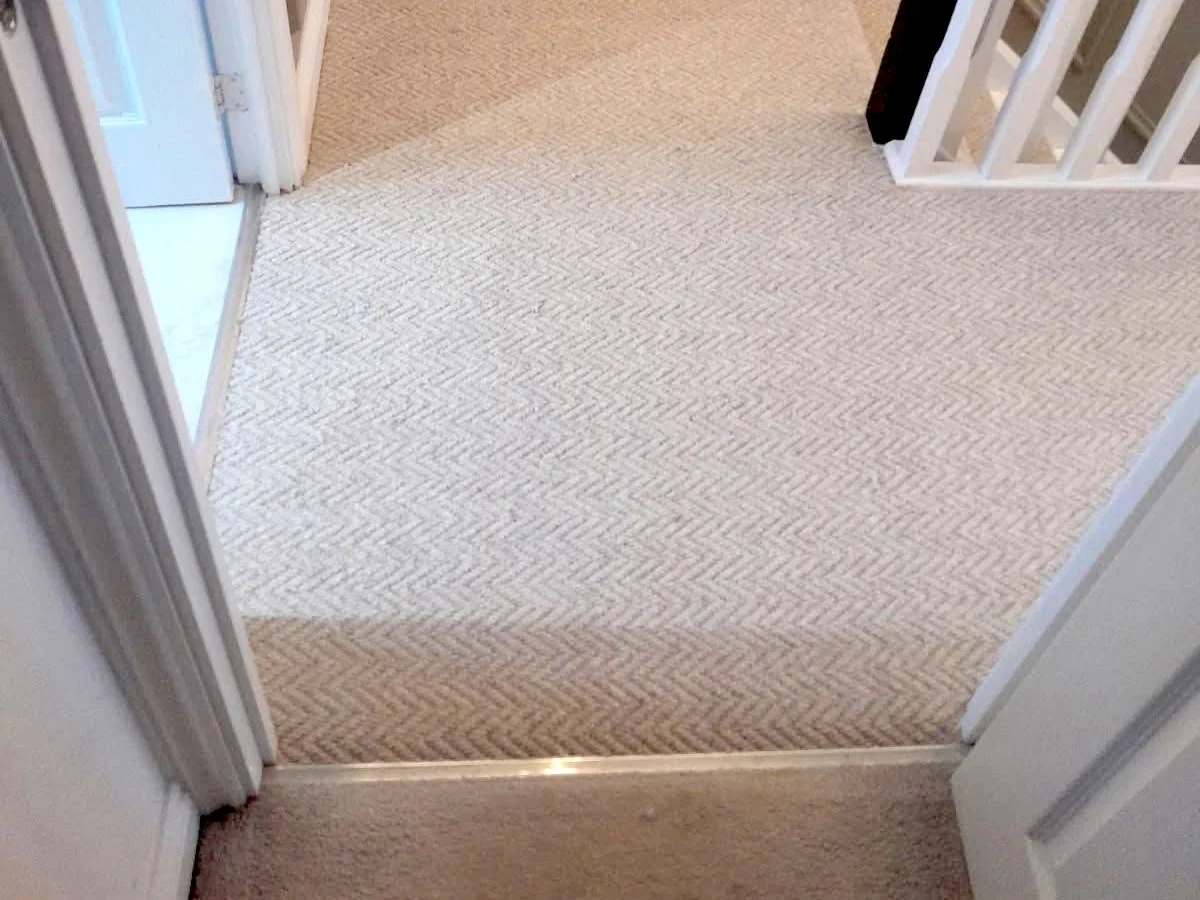 landing-carpet-herringbone-beige-door-threshold-newcastle-foxglove-flooring Carpet trimmed neatly at a door threshold — doors still clear