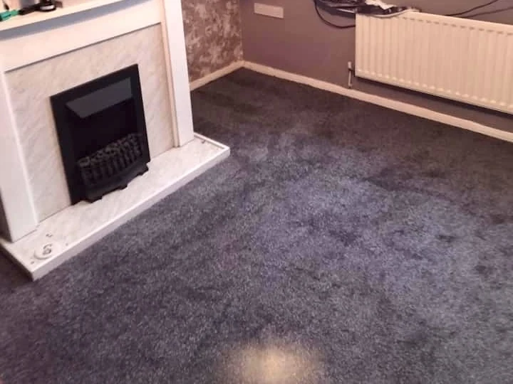 Deep grey carpet beside a marble fireplace — carpet fitters covering Ouseburn