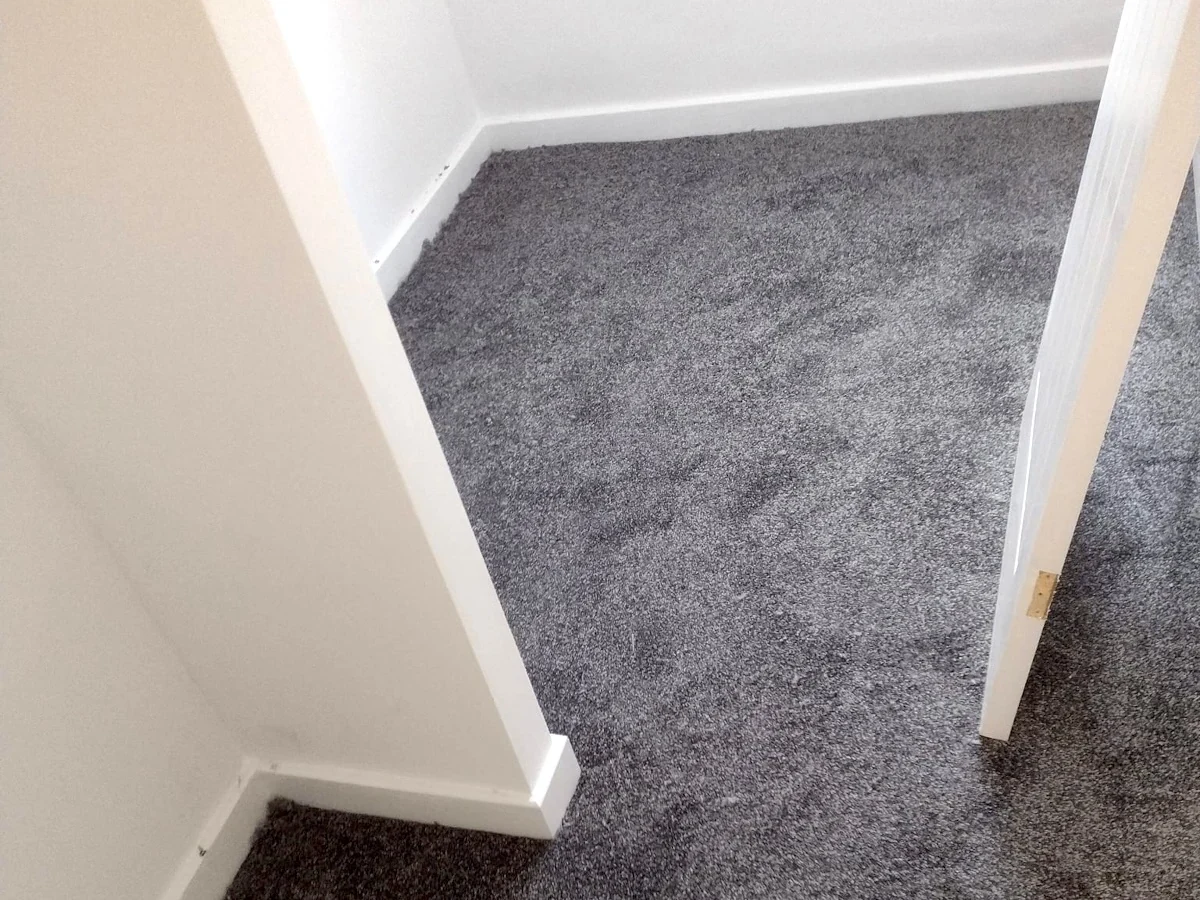 Grey carpet fitted into an under-stairs corner — carpet fitters covering Cramlington